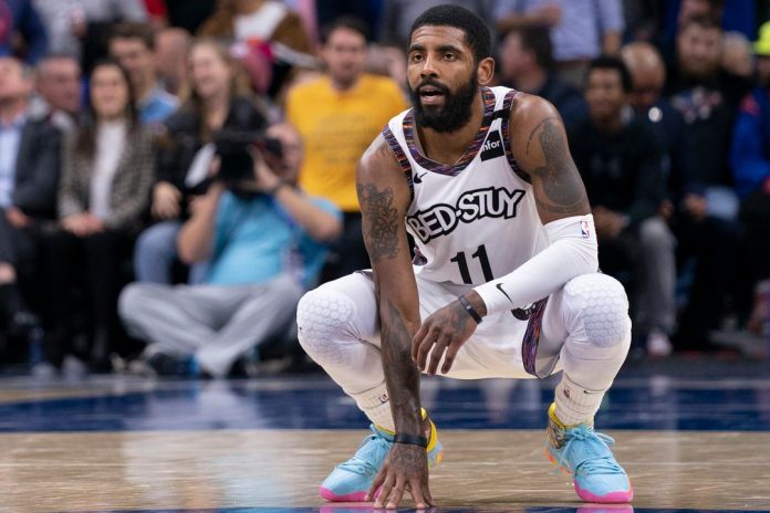 Kyrie Irving kneeling wearing a Brooklyn Nets jersey