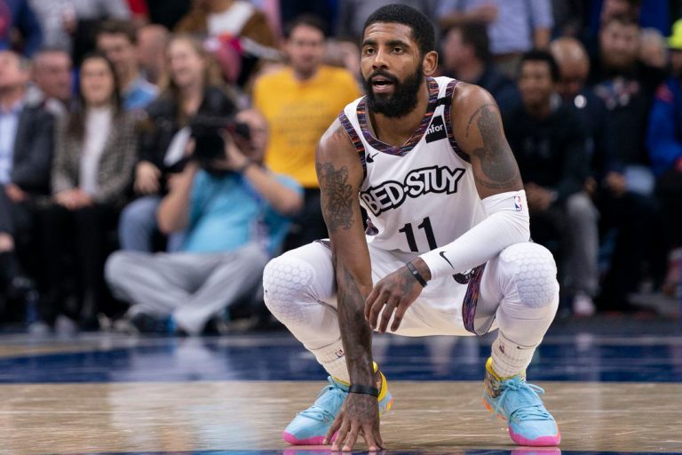 Kyrie Irving kneeling wearing a Brooklyn Nets jersey